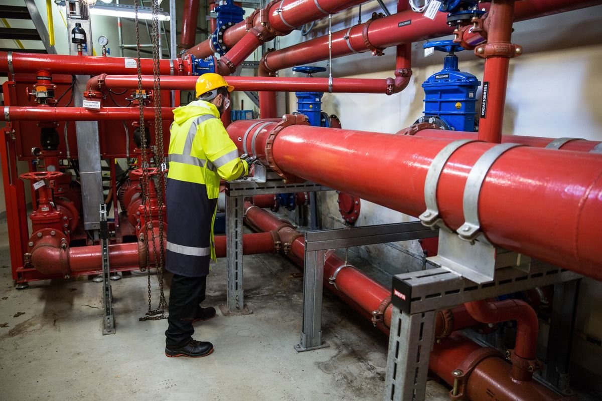 Technician inspecting composite-repaired piping